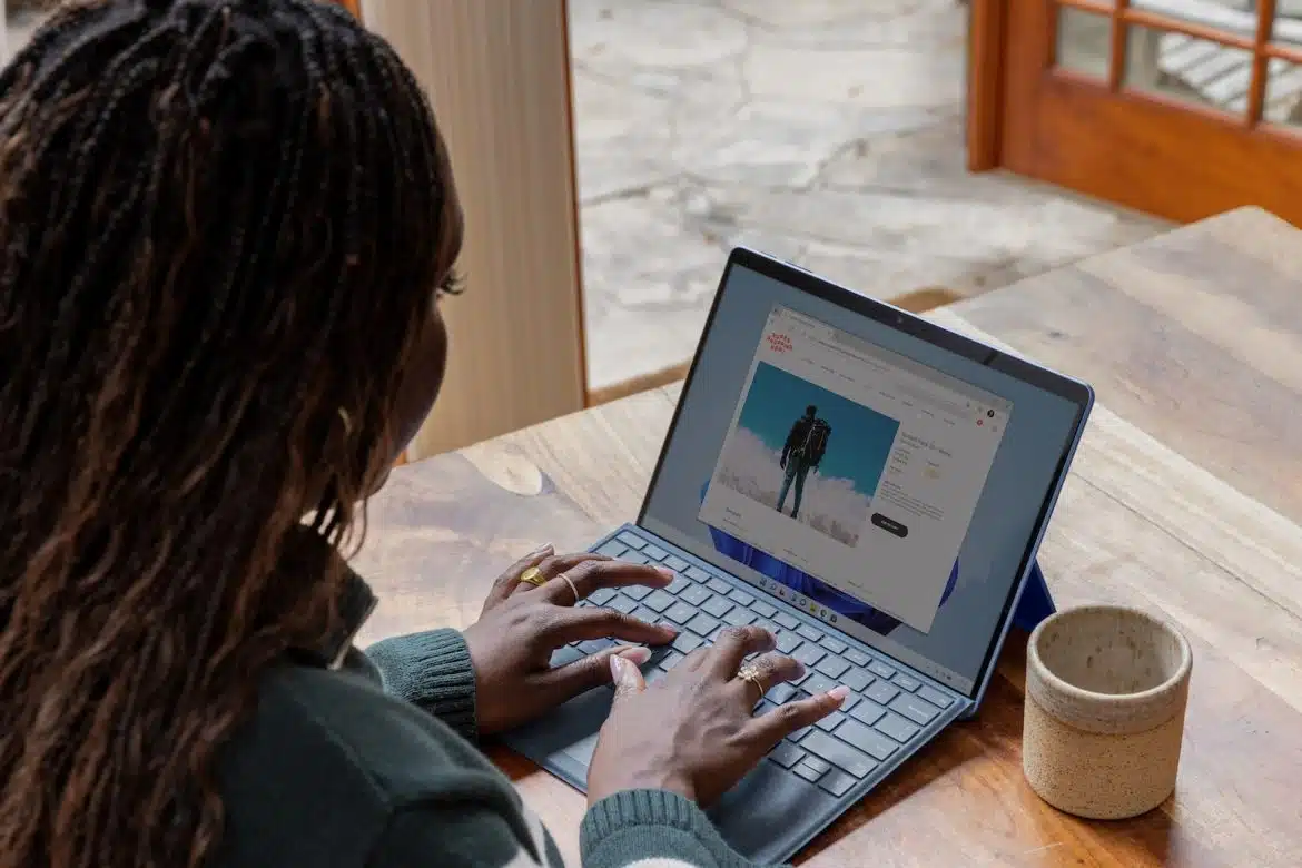 a woman sitting at a table using a laptop computer